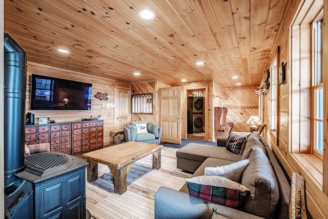 living room with stacked washer / dryer, wood ceiling, and wooden walls