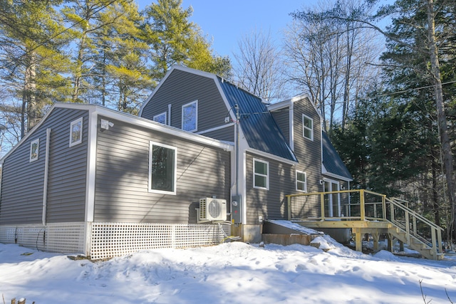 view of snowy exterior featuring ac unit and a deck