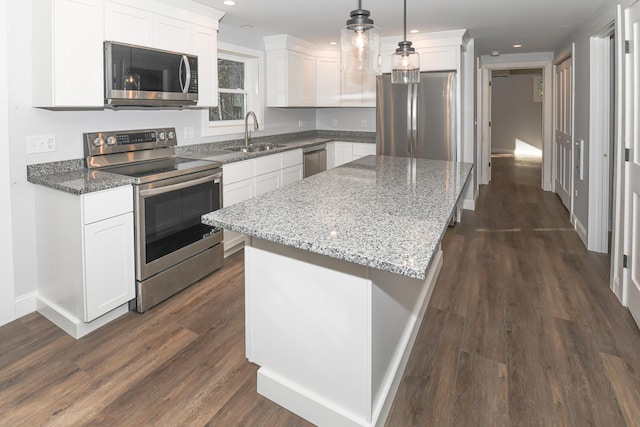 kitchen featuring sink, a center island, pendant lighting, stainless steel appliances, and white cabinets