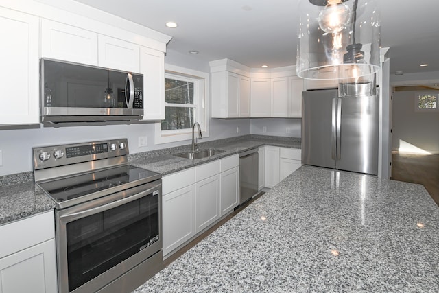 kitchen with white cabinetry, sink, stone counters, and appliances with stainless steel finishes