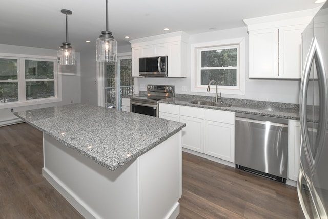 kitchen featuring sink, white cabinetry, decorative light fixtures, a kitchen island, and stainless steel appliances