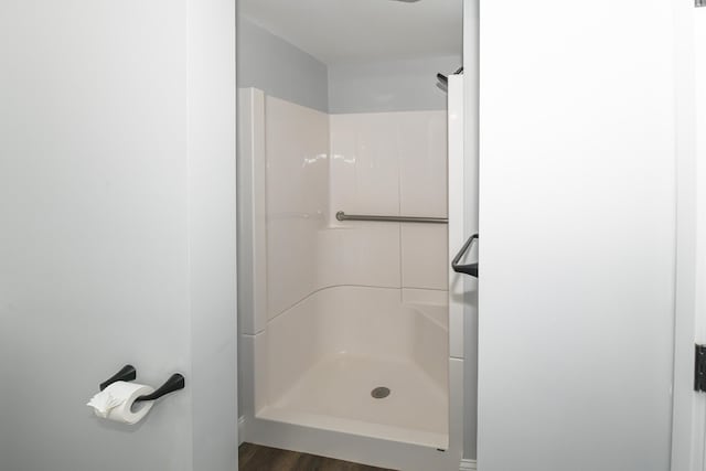 bathroom with hardwood / wood-style floors and a shower