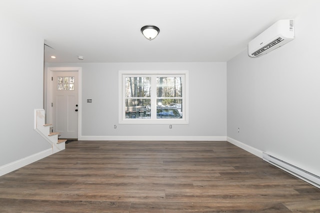 foyer with dark hardwood / wood-style flooring, a wall unit AC, and a baseboard heating unit