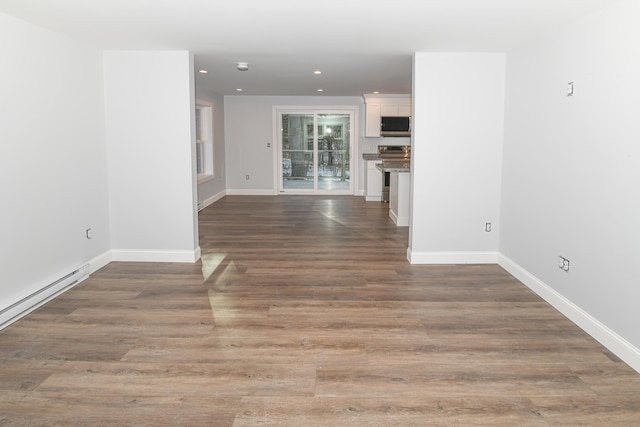 unfurnished living room with dark wood-type flooring and a baseboard radiator