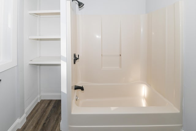 bathroom featuring wood-type flooring and  shower combination