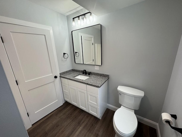 bathroom featuring vanity, hardwood / wood-style floors, and toilet