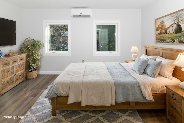 bedroom with dark hardwood / wood-style floors and a wall unit AC