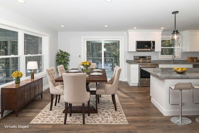 dining space with dark hardwood / wood-style flooring, sink, and a healthy amount of sunlight