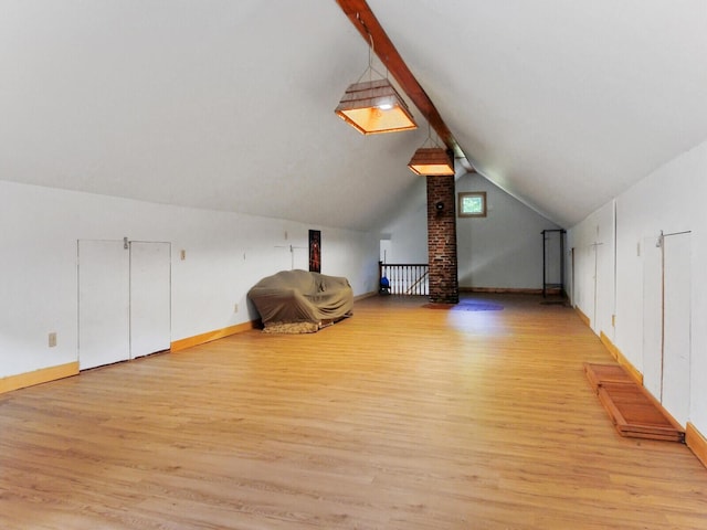 additional living space featuring vaulted ceiling and light hardwood / wood-style flooring