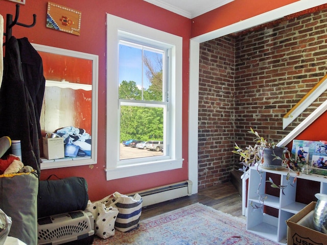 interior space featuring a wealth of natural light, ornamental molding, hardwood / wood-style flooring, and a baseboard radiator