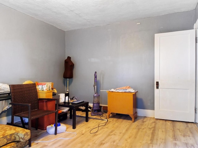 misc room with a textured ceiling and light hardwood / wood-style flooring