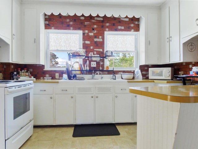 kitchen featuring white cabinets, tasteful backsplash, and white appliances