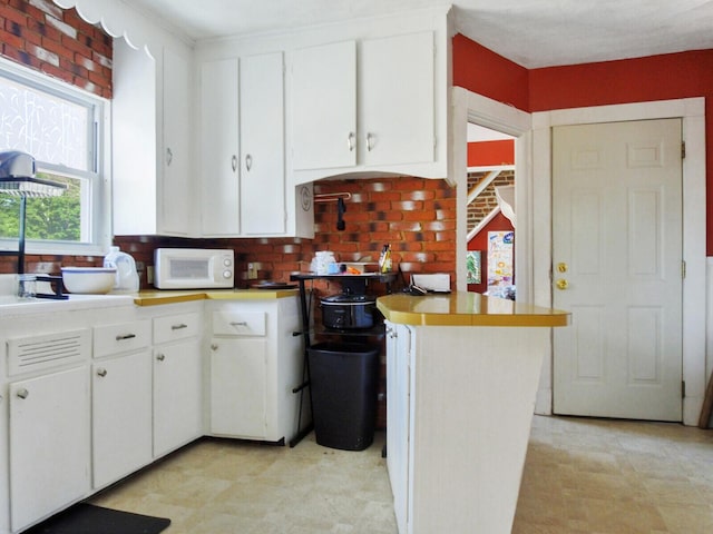 kitchen with backsplash and white cabinets