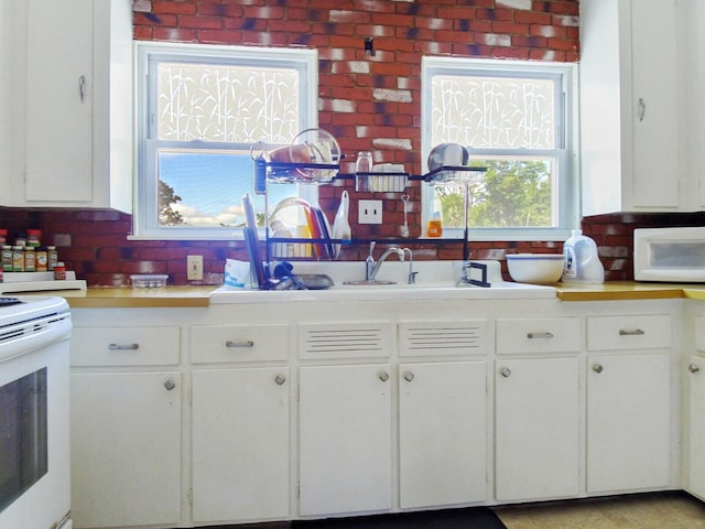 kitchen with backsplash, white cabinetry, and white appliances