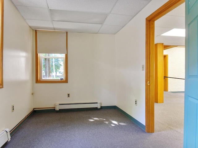 spare room featuring a baseboard radiator, carpet, and a paneled ceiling