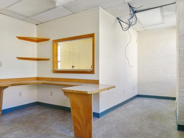 interior space featuring a drop ceiling and kitchen peninsula