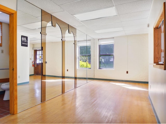 empty room featuring light hardwood / wood-style floors and a paneled ceiling