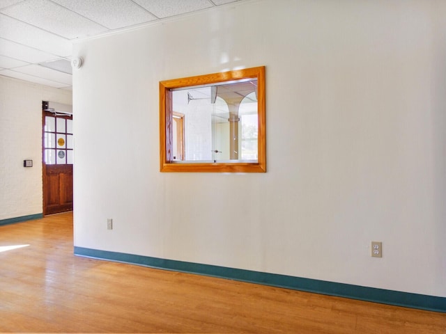 spare room featuring light hardwood / wood-style floors and a drop ceiling