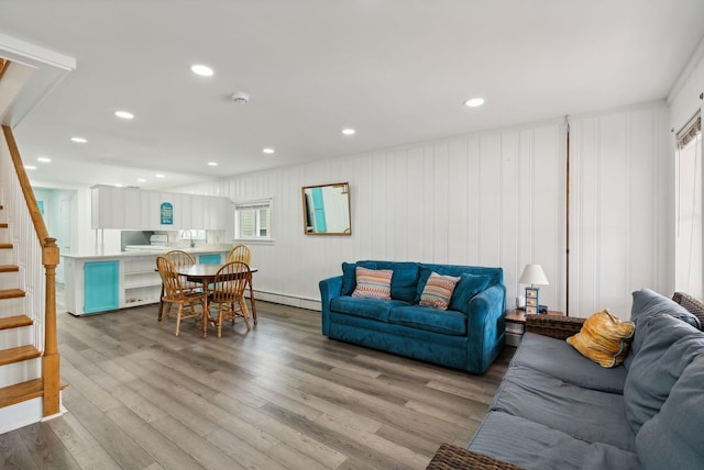 living room with baseboard heating and light hardwood / wood-style flooring