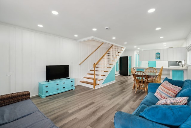 living room featuring ornamental molding, light hardwood / wood-style floors, and sink