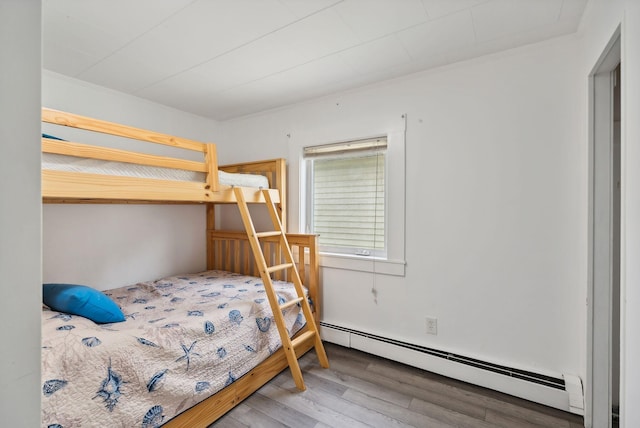 bedroom with hardwood / wood-style flooring and a baseboard radiator