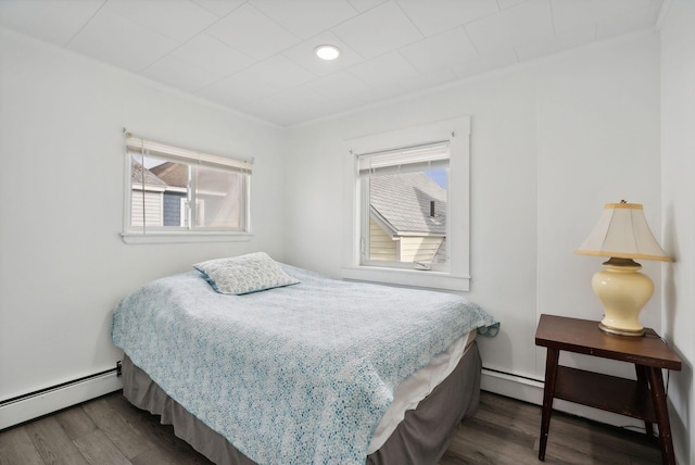 bedroom with baseboard heating, multiple windows, and dark hardwood / wood-style flooring