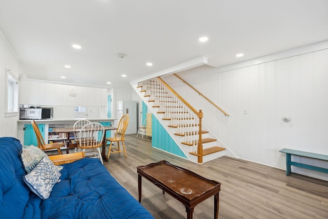 living room with ornamental molding and light wood-type flooring