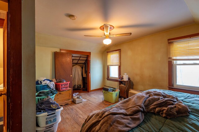 bedroom with ceiling fan, vaulted ceiling, and multiple windows