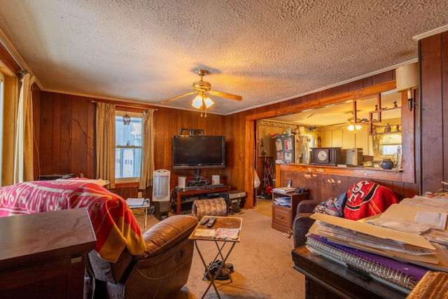 living room featuring ceiling fan, light colored carpet, a textured ceiling, and wood walls