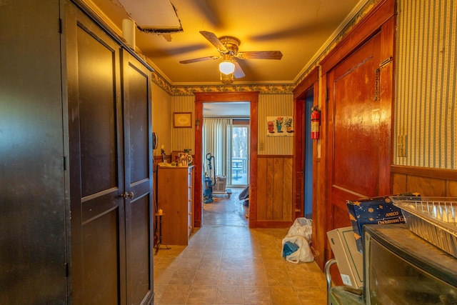 interior space featuring ceiling fan, separate washer and dryer, wood walls, and crown molding