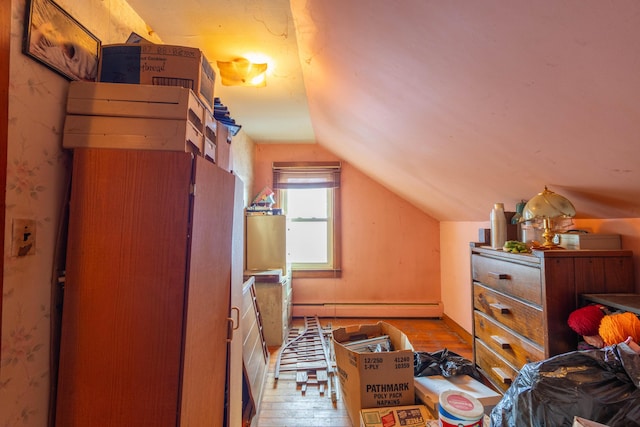 interior space with baseboard heating, light hardwood / wood-style flooring, and lofted ceiling