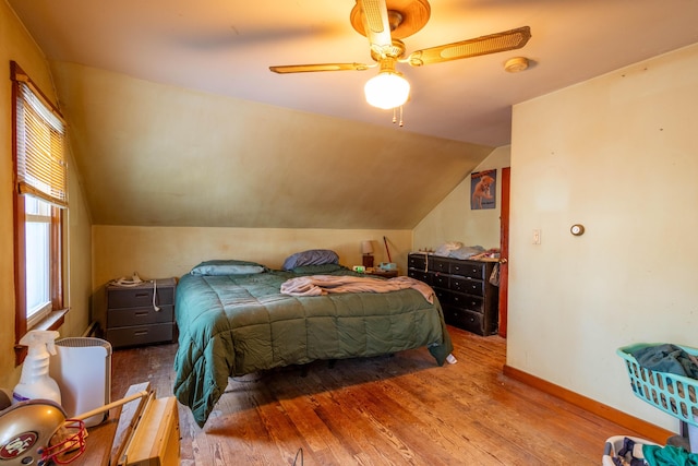 bedroom with ceiling fan, hardwood / wood-style floors, and lofted ceiling