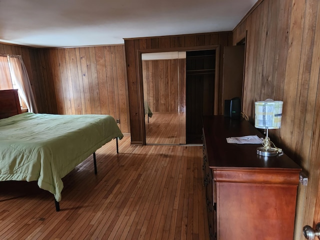 bedroom featuring hardwood / wood-style floors and wooden walls