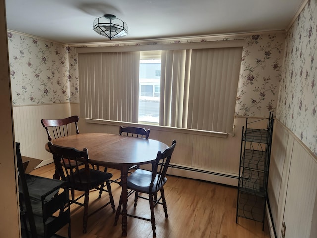 dining space with a baseboard radiator and wood-type flooring