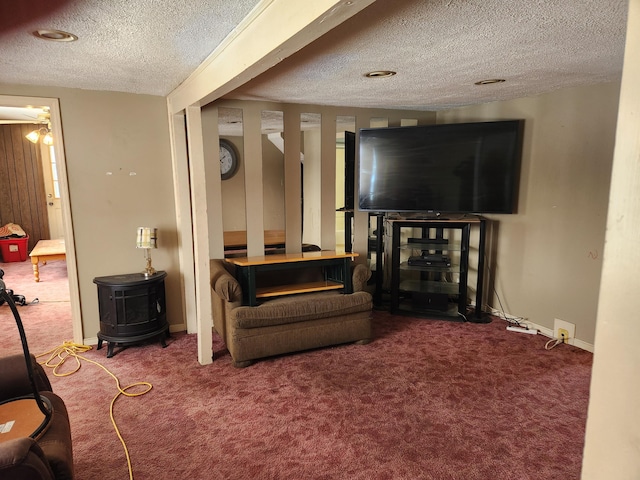 living room with carpet flooring, a textured ceiling, and a wood stove