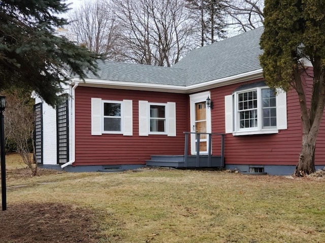 view of front facade featuring roof with shingles and a front lawn