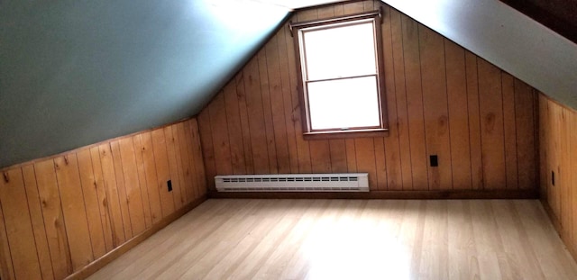 bonus room featuring light wood-type flooring, wood walls, a baseboard radiator, and vaulted ceiling