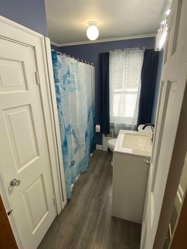 bathroom featuring ornamental molding, vanity, toilet, and wood finished floors