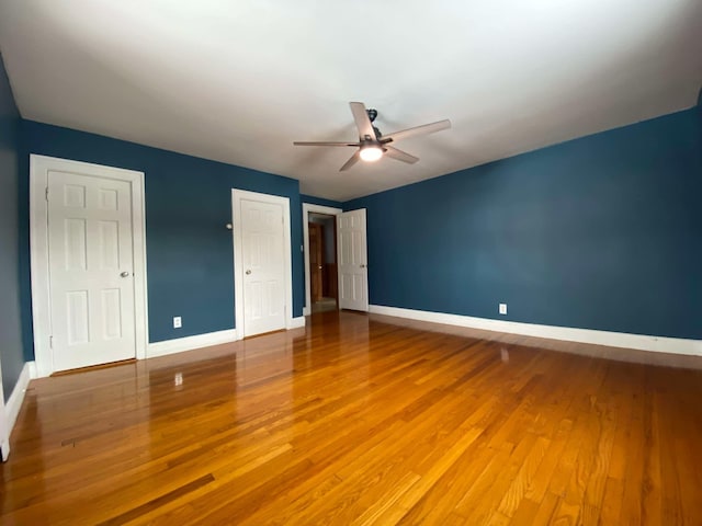 unfurnished bedroom with ceiling fan, baseboards, and wood finished floors