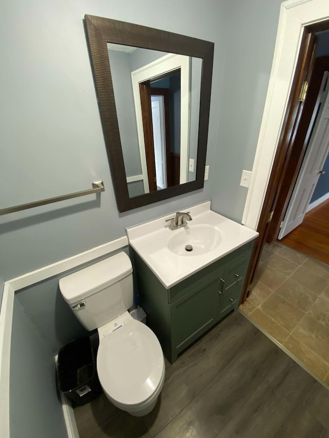 bathroom with vanity, toilet, and wood finished floors