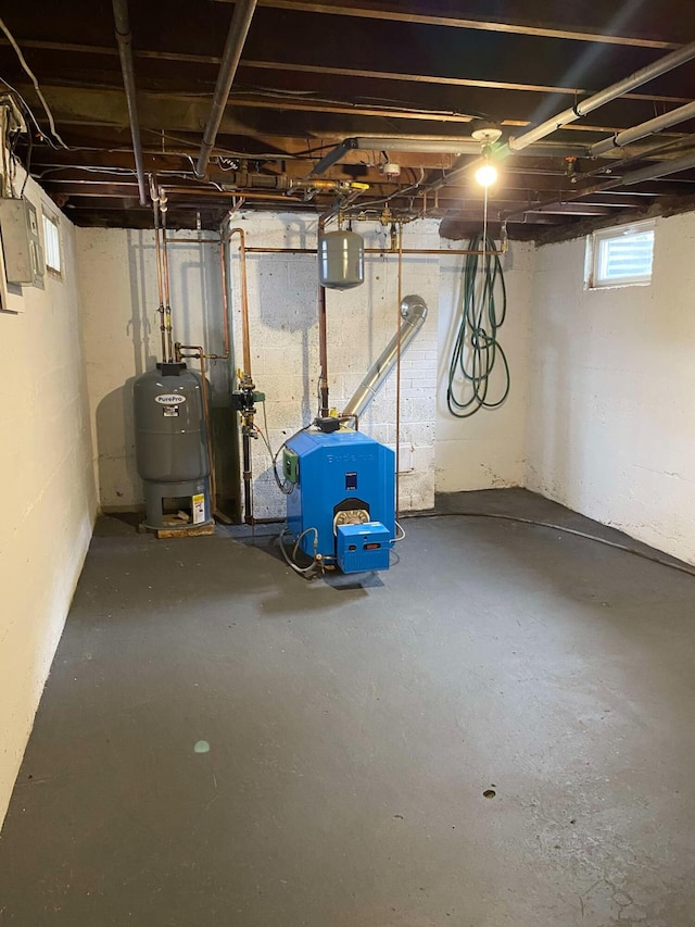 basement featuring a heating unit and secured water heater