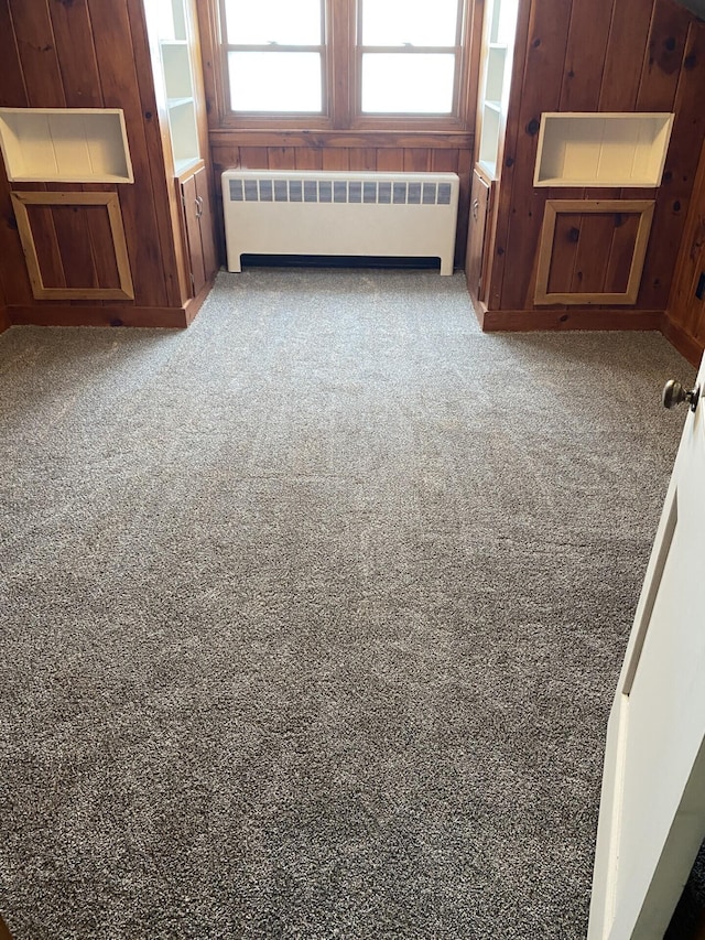 spare room featuring carpet, radiator, and a healthy amount of sunlight