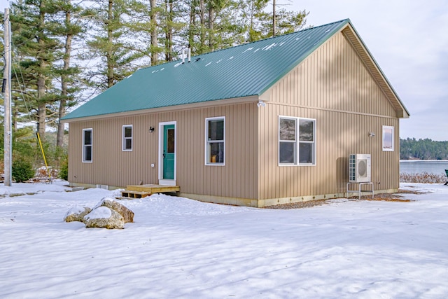 snow covered rear of property with ac unit