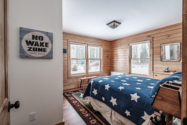 bedroom with wood walls and hardwood / wood-style floors