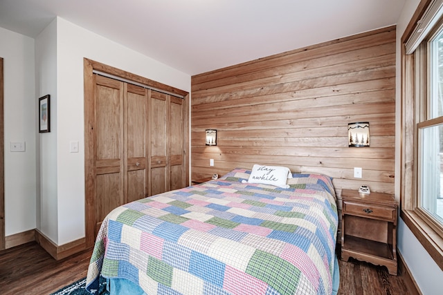 bedroom featuring dark wood-type flooring, a closet, and wooden walls