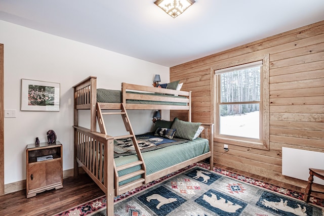 bedroom featuring dark hardwood / wood-style floors and wood walls