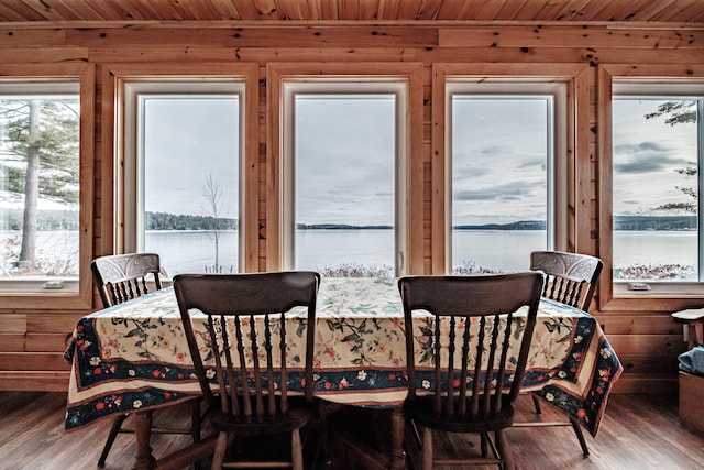 dining area with wooden ceiling, a water view, and hardwood / wood-style flooring