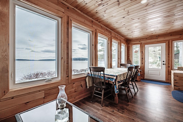 dining space with a water view, wood ceiling, and dark hardwood / wood-style flooring