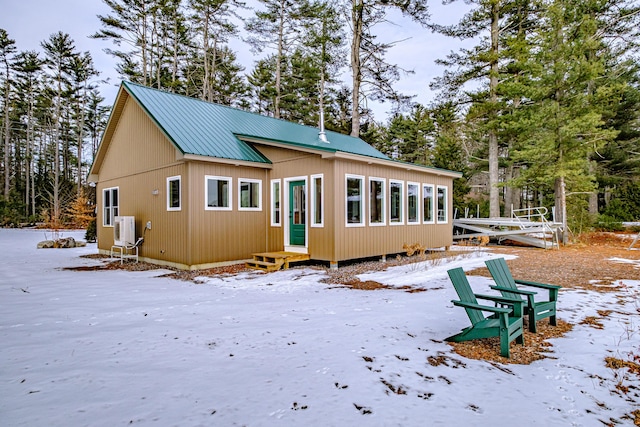 snow covered back of property with ac unit