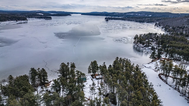 snowy aerial view featuring a water and mountain view